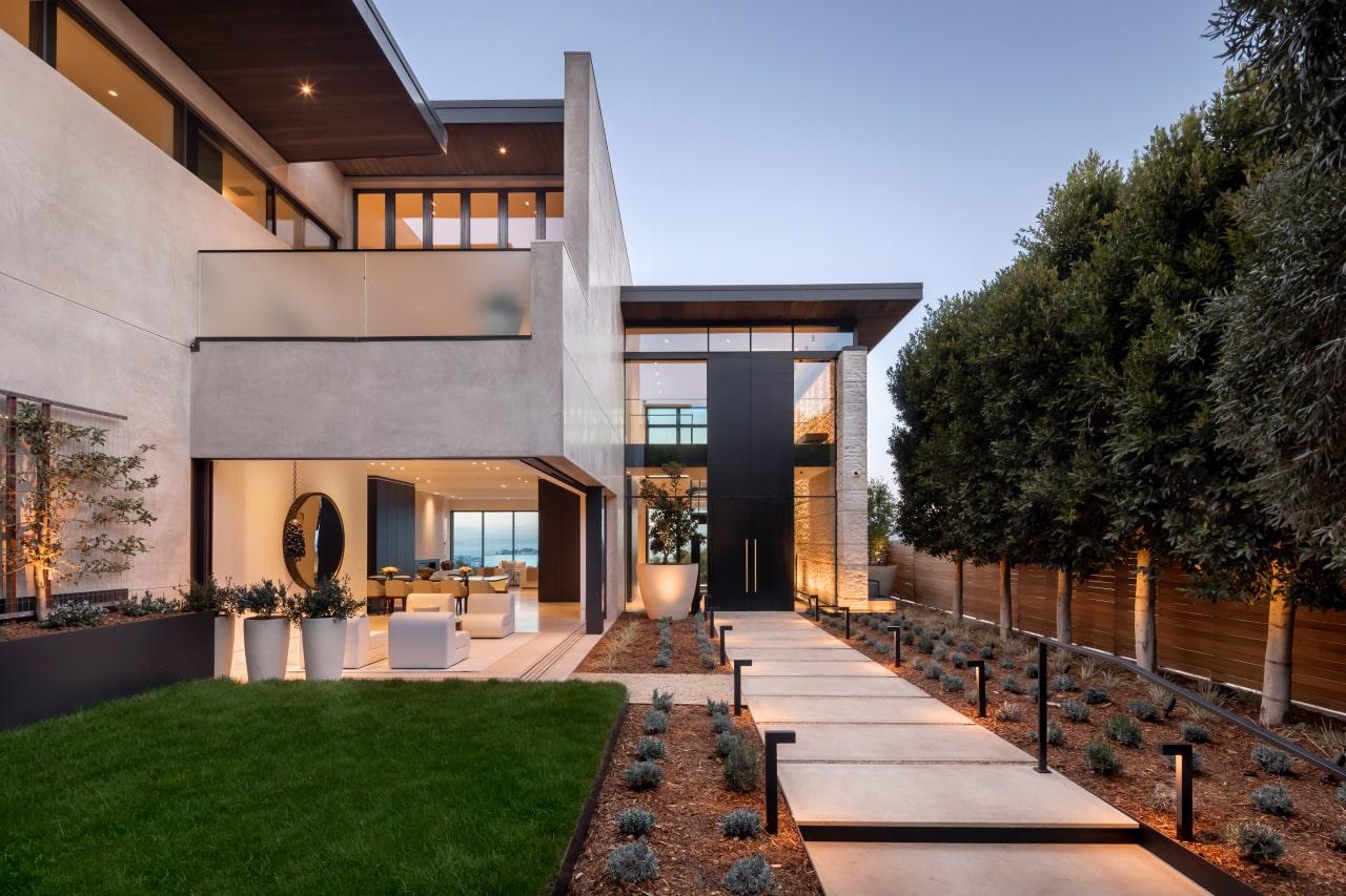 Contemporary luxury residence at dusk with a lit stone entrance walkway